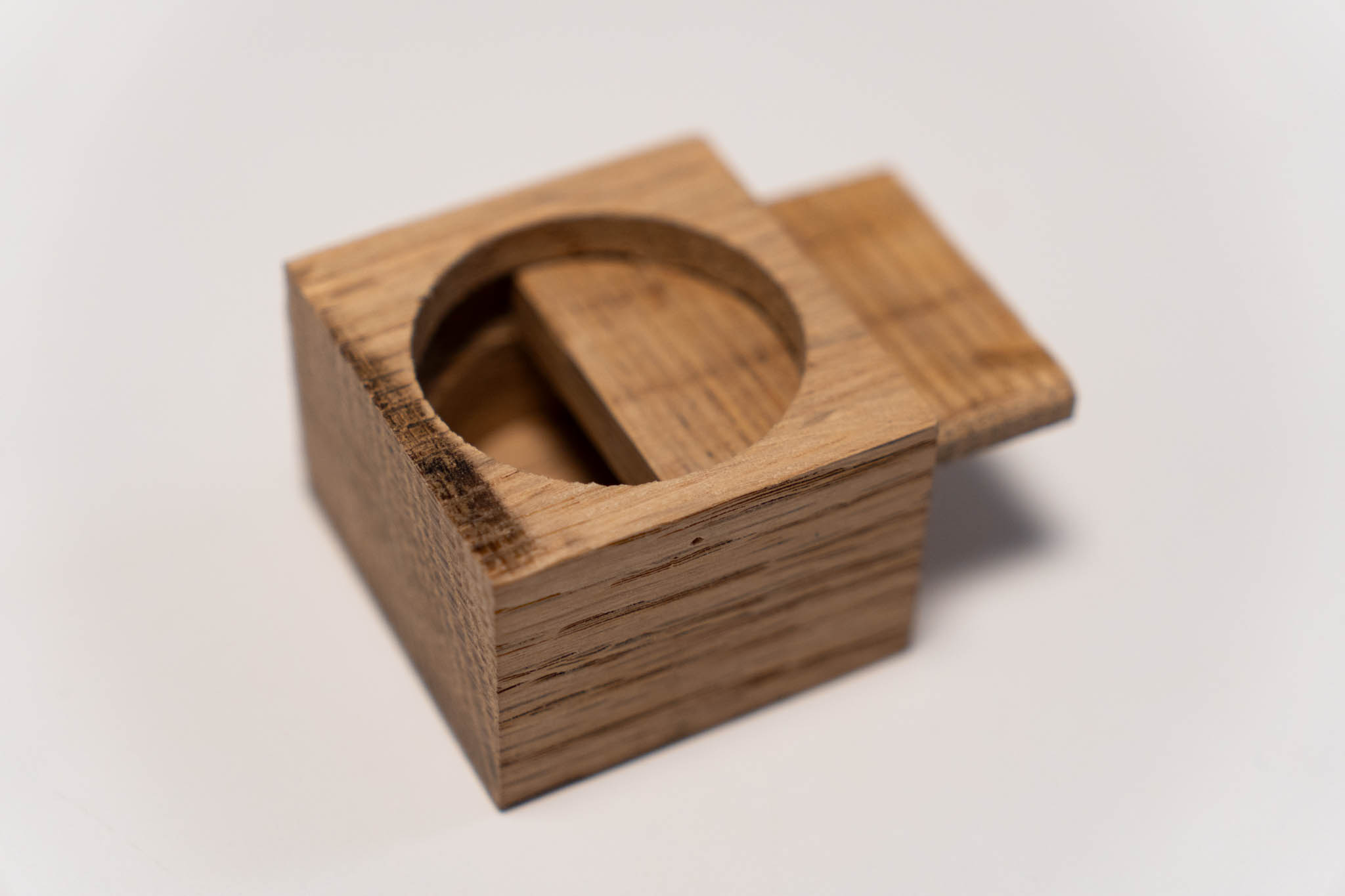 a small rectangular wooden light-brown box with its lid half inserted