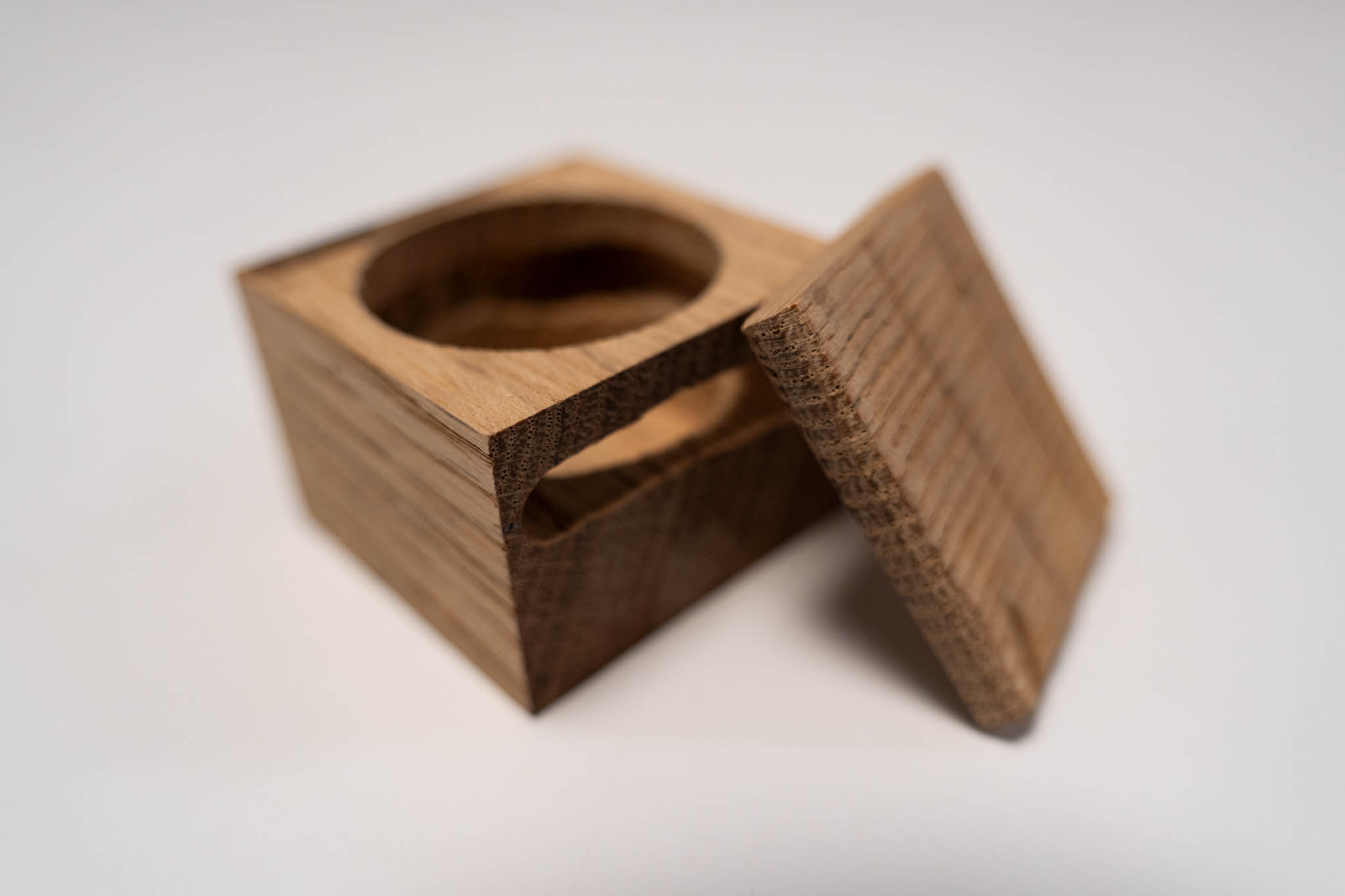 a small rectangular wooden light-brown box with its lid leaning against it